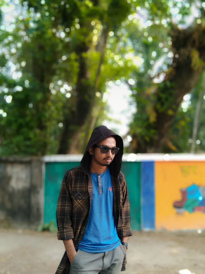 Sefat Khan wearing sunglasses and a hooded checked jacket outdoors